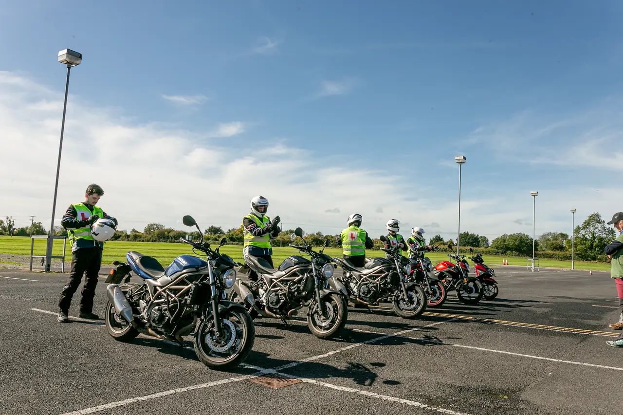 Instructor with a line of learner riders and their motorcycles on the training yard at Fairyhouse Racecourse, Ratoath
